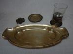 Quatro peças em metal espessurado a prata: travessa, porta-copo, pratinho e porta-alianças. Ornamentação diversa. Travessa 17 x 34cm.