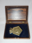 Caixa em madeira nobre, no interior brasão em metal amarelo do Contra-Torpedeiro Pernambuco (D 30). 7 x 28 x 19cm.