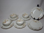 Parte de conjunto para chá em porcelana nacional branca, composto por 4 xícaras e pires e 4 pratos de sobremesa, borda filetada a ouro, decorados por arranjos de rosas policromadas. Fundo marcado Renner. Diâm. pratos 17cm.