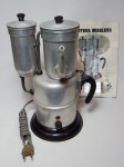 Antiga cafeteira elétrica em alumínio, cabos em plástico fenólico. Década de 50. Manufatura Cafeteira Elétrica S.A., 115V. Acompanha folheto com instruções de uso. Sem uso. Não testada e sem garantias. No estado. Alt. 32cm.