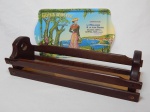 Duas peças: a) Cesta para pães em madeira ripada, 12 x 41 x 14cm b) Bandeja em plástico com cena de propaganda francesa. 33 x 20cm.