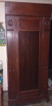 Guarda casaca Art Nouveau, em madeira nobre, 1 porta, ilhargas entalhadas com caneluras, interior com 1 prateleira. Desgastes na madeira. Cerca 1920. 223 x 93 x 56cm.