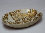 Petisqueira em vidro turco na tonalidade bege, moldado com acantos e volutas em dourado. Etiqueta de procedência no fundo. 4,5 x 21 x 14,5cm.