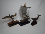 Três esculturas em metal: Barco à vela, base em mármore; Avião e Golfinho, bases em madeira. Apresentam oxidação. No estado. Alts totais 22  e 9,5cm.