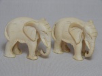 Dois elefantes africanos esculpidos em marfim. Alts. 4cm.