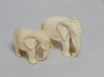 Dois elefantes africanos esculpidos em marfim. Alts. 4,5 e 3,5cm.