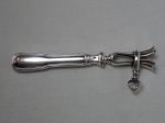 Pegador de ossos (pernil ou frango), metal espessurado à prata, cabo no estilo clássico. Contrastado Alfenide e marcado Deposé. Comp. 21cm.