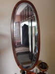 Espelho oval bisotée, moldura de madeira nobre. 138 x 58cm.