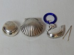 Três peças em metal espessurado a prata; 2 caixinhas porta pílulas, 1 na forma de concha e 1 abaulada e chocalho na forma de pato. Diams. 6 - 4 e 4 x 5cm.