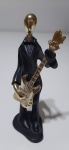 Miniatura figura de músico com guitarra, peça confeccionada em resina. Bom estado de conservação.