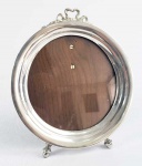 LINDO PORTA RETRATOS EM PRATA DE LEI COM FUNDO EM MADEIRA (FORMA PAR COM O DO LOTE ANTERIOR). FEITIO CIRCULAR. ELEGANTE DECORAÇÃO REMATADA POR LAÇAROTE NO TOPO. EUROPA, INICIO DO SEC. XX.  17,5 CM DE ALTURA