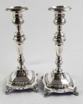 MAGNÍFICO PAR DE CASTIÇAIS EM PRATA DE LEI ESTILO E ÉPOCA DONA MARIA I. MARCAS DE CONTRASTE DE OURIVES PORTUGUES ATUANDO NO RIO DE JANEIRO A PARTIR DE 1810 (MOITINHO PAG 375). É DE SUA LAVRA, A MAGNIFICA URNA DE HONRA OFERECIDA PELOS COMERCIANTES DO PORTO A JOSÉ DA SILVA CARBALHO QUE FOI MINISTRO DE DOM JOÃO VI, DOM PEDRO I (COMO PEDRO IV DE PORTUGAL) E DONA MARIA II (DONA MARIA DA GLÓRIA), PRINCESA BRASILEIRA QUE SE TORNOU RAINHA DE PORTUGAL. ELEGANTE CONSTRUÇÃO COM FUSTE REQUINTADO COM CINZELADOS E ROCAILLE FEITIO SEXTAVADO NA PARTE CENTRAL. BASE MOVIMENTADA E PÉS EM CAPRICHADAS GARRAS. BRASIL, INICIO DO SEC. XIX. 25 CM DE ALTURA, 925 G