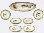 A. CARREN & F. GUILLIERME  PARIS -  LIMOGES  FAUSTOSO CONSUNTO PARA PEIXE EM PORCELANA DE LIMOGES COM LINDA DECORAÇÃO REPRESENTANDO AMBIENTE AQUÁTICO COM PEIXES. RICA DECORAÇÃO REALÇADA EM OURO. O CONJUNTO É COMPOSTO POR GRANDE TRAVESSA DE SERVIÇO E SEIS PRATOS. PINTURA EM ESMALTES APLICADOS MANUALMENTE. EXCELENTE ESTADO DE CONSERVAÇÃO! FRANÇA, FINAL DO SEC. XIX. 60 CM DE COMPRIMENTO (TRAVESSA)