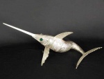 GRANDE E REALISTA ESCULTURA EM PRATA DE LEI COM FEITIO DE PEIXE ARTICULADO. PRIMOROSO TRABALHO COM DELICADO CINZELADO FORMANDO AS ESCAMAS. COMPOSTO POR DEZENAS DE SEGMENTOS ARTICULADOS QUE LHE CONFEREM MOVIMENTO. ESPANHA, MEADOS DO SEC. XX. 44 CM DE COMPRIMENTO. 355 G