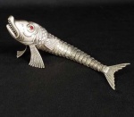 REALISTA ESCULTURA EM PRATA DE LEI TEOR 925 COM FEITIO DE PEIXE ARTICULADO. PRIMOROSO TRABALHO COM DELICADO CINZELADO FORMANDO AS ESCAMAS. COMPOSTO POR DEZENAS DE SEGMENTOS ARTICULADOS QUE LHE CONFEREM MOVIMENTO. ESPANHA, MEADOS DO SEC. XX. 14 CM DE COMPRIMENTO.