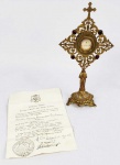 EX CAPPILIS -  SANTA MARIE-BERNARD SOUBIROUS (SANTA BERNARDETE)  -  RELIQUIA QUE PERTENCEU A  SUA EXCELENCIA REVERENDISSIMA DOM ANTONIO ALVES DE SIQUEIRA, BISPO AUXILIAR DE ARICANDA, BISPO AUXILIAR DE SÃO PAULO E ARCEBISPO DE CAMPINAS. RELÍCARIO COM RELÍQUIA DE SANTA BERNARDETE, QUE FOI A MENINA A QUEM NOSSA SENHORA DE LOURDES APARECEU NA FRANÇA EM 1858. O RELICÁRIO É EM BRONZE DOURADO, O FUSTE TEM REPRESENTAÇÃO DE NOSSA SENHORA DE LOURDES. NA PARTE SUPERIOR, DELICADA DECORAÇÃO FENESTRADA COM RAMAGENS E FLORES EM ESTILO NEOGOTICO. INTERIOR CONTÉM TECA ONDE ESTÁ UM FIO DE CABELO DE SANTA BERNARDETE E A INSCRIÇÃO S. M. BERNARDAE. POSSUI CARTA TESTEMUNHAL DE AUTENTICAÇÃO ASSINADA E SELADA PELO BISPO DE NEVERS, DOM PATRICE FLYNN DATADA DE 10 DE MAIO DE 1958. A RELIQUIA TAMBÉM ESTÁ SELADA COM O BRASÃO DO BISPO DE NEVERS EM CERA. FRANÇA, MEADOS DO SEC. XX. 21 CM DE ALTURA.NOTA: Marie-Bernard Soubirous ou Maria Bernarda Sobeirons em occitano (Lourdes, 7 de Janeiro de 1844  Nevers, 16 de Abril de 1879) foi uma religiosa francesa, canonizada pela Igreja. É conhecida por ter sido a menina a quem a Virgem Maria teria aparecido em Lourdes, na França.  Filha de um pobre moleiro chamado Francisco Soubirous e de Luísa Castèrot, a francesa Bernadette foi a primeira de nove filhos. Na infância, ela trabalhou como pastora e criada doméstica. O pai esteve preso sob a acusação de furto de farinha, contudo foi absolvido.  Durante os dez primeiros anos, a menina morou no moinho de Boly (onde nasceu). Passando por graves dificuldades financeiras, a família mudou-se depois para Lourdes, onde vivia em condições de miséria, morando no prédio da antiga cadeia municipal, que fora abandonado pouco antes. Apesar de parecer insalubre, todos viviam no andar superior do edifício, ocupado pelo primo de Francisco Soubirous, pai de Bernadette. Era um buraco infecto, sombrio, e a divisão inabitável da antiga prisão abandonada por causa da insalubridade. Desde pequena, Bernadette teve a saúde debilitada devido à extrema pobreza de sua habitação. Nos primeiros anos de vida foi acometida pela cólera, o que a deixou extremamente enfraquecida. E, por causa também do clima frio no inverno, adquiriu asma, aos 10 anos. Tinha dificuldades de aprendizagem formal e na catequese, o que fez com que a sua primeira comunhão fosse atrasada. Não pôde frequentar a escola, mantendo-se analfabeta até os 14 anos. No dia 11 de fevereiro de 1858, em Lourdes - cidade com cerca de quatro mil habitantes -, Bernadette disse ter visto a aparição de uma "senhora" envolta de uma luz na gruta denominada massabielle ( "pedra velha" ou "rocha velha"), junto à margem do rio Gave. Outras aparições sucederam até que Bernadette perguntou à "senhora" quem ela era. Segundo seu relato ao pároco local, Pe. Dominique, a resposta foi: "Eu sou a Imaculada Conceição". O que causou espanto e comoção ao padre, que sabia que a moça não estava inventando: ela não tinha nenhum conhecimento do significado de suas palavras, muito menos conhecimento do dogma "Imaculada Conceição", então recentemente promulgado pelo Papa. Enquanto o assunto era submetido à hierarquia eclesiástica, que se comportava com cética prudência, curas cientificamente inexplicáveis foram verificadas na gruta de "massabielle". Em 25 de fevereiro de 1858, na presença de uma multidão, surgiu sob as mãos de Bernadette uma fonte - que jorra água até os dias de hoje, cerca de cinco mil litros por dia. Bernadette afirmou ter tido 18 visões da Virgem Maria, no mesmo local, entre 11 de fevereiro à 16 de julho de 1858. E defendeu a autenticidade das aparições com uma firmeza incomum para uma adolescente com temperamento humilde e obediente, além de níveis baixíssimos de instrução e sócio-econômico. Manteve-se contra a opinião de sua família, do clero e das autoridades públicas. Foi submetida, pelas autoridades civis, a métodos de interrogatórios, constrangimentos e intimidações inadmissíveis. Mas nunca vacilou em afirmar, com toda a convicção, a autenticidade das aparições, o que fez até a sua morte, em 1879. Em 1860, para fugir à curiosidade geral e assédio, Bernadette refugiou-se, como "pensionista indigente", no Hospital das Irmãs da Caridade de Nevers, em Lourdes. Ali recebeu instrução e, em 1861, fez de próprio punho o primeiro relato escrito das visões de Nossa Senhora. No dia 18 de janeiro de 1862, Monsenhor Bertrand Sévère Laurence, Bispo de Tarbes, reconheceu pública e oficialmente a realidade do fato das aparições. Em julho de 1866, Bernadette inicia o noviciado no convento de Saint-Gildard e, em 30 de outubro de 1867, faz a profissão de religiosa da Congregação das Irmãs da Caridade de Nevers. Dedicou-se à enfermagem até ser imobilizada, em 1878, pela doença que lhe causou a morte. Uma imensa multidão assistiu ao seu funeral, em 19 de abril de 1879, sendo necessário ser adiado por causa da grande afluência de pessoas. Em 20 de agosto de 1908, Monsenhor Gauthey, bispo de Nevers, constituiu um tribunal eclesiástico para investigar "o caso Bernadette Soubirous".  Em virtude das divulgadas manifestações divinas nos arredores da cidade, uma grande massa peregrinatória se formou em direção à gruta, estimulada pelos rumores de curas milagrosas por intermédio da água da fonte de Nossa Senhora de Lourdes. A pedido do comissário de polícia, Jacomet, o prefeito de Lourdes, Alexis Lacadé, tomou a decisão de proibir, a partir de 8 de junho de 1858, o acesso à gruta. Três meses depois, o Imperador Napoleão III e a Imperatriz Eugênia estavam em Biarritz. E a imperatriz, informada dos acontecimentos ocorridos em Lourdes, solicitou ao imperador que pedisse explicações ao arcebispo de Auch, metropolitano de Tarbes e Lourdes. Depois, determinou ao ministro de Cultos: "Desejo que o acesso à gruta fique livre, como também o uso da água do manancial." No dia 2 de outubro de 1858, foi retirada a proibição de acesso à Gruta de Massabielle. E Lourdes, rapidamente, tornou-se um dos mais importantes centros de peregrinação da cristandade, até hoje. Segundo o biógrafo de Bernadette, Francis Trochu, os fatos foram acompanhados de perto pelo doutor Douzous, na época médico de Lourdes - um burguês conhecido por sua ciência e filantropia, mas que não era frequentador da Igreja, salvo em eventos sociais ou festas oficiais. Em razão do "milagre do círio", em 7 de abril de 1858, durante a 17.ª aparição da Virgem, o Dr. Douzous se convenceu da boa-fé de Bernadette. Naquele dia, o médico observou que enquanto se encontrava em "êxtase" Bernadette tinha na mão direita um círio grande aceso, e, a certa altura, todos viram com assombro e pavor a chama do círio enrolar-se à volta da sua mão esquerda sem a queimar. O médico observou o fenômeno atentamente com o relógio em punho: o acontecimento durou 15 minutos. Ao fim do êxtase, ele examinou a mão de Bernadette e não viu sinal de queimadura. Tentou, então, aproximar a chama das suas mãos após a sua volta ao estado normal, o que a fez reagir e gritar: "Mas o senhor está queimando-me". Perplexo, o médico declarou acreditar por ter visto com os próprios olhos. Bernadette Soubirous é, seguramente, uma das personalidades femininas mais veneradas por dulia ao redor do mundo. Tal título, pode ser expresso pelo relativamente curto período tempo a qual foi sujeita às burocracias impostas pela Santa Sé para que lhe fosse autorizado o culto público legal. O fato de seu corpo incorrupto (o qual lhe rendeu o nome popular de "Santa Dormente"), seus supostos milagres não-póstumos e as crenças acerca de suas visões da Virgem Maria em Lourdes, foram fatores decisivos para que a população de Nevers, onde morreu, da França e até mesmo da Europa rapidamente a incorporassem como santa, até mesmo antes de sua morte. Pressionados pela grande massa popular que queria Bernadette canonizada, o então Papa autorizou seu culto como venerável. Após quase 150 anos, não existe o mínimo sinal de putrefação. Em 22 de setembro de 1909, trinta anos após o velório, seu cadáver foi exumado e o corpo encontrado intacto.Relatório dos Drs. David e Jordan, que conduziram a primeira exumação: O caixão foi aberto na presença do Bispo e do Prefeito de Nevers, seus principais representantes e diversos religiosos. Não notamos nenhum odor. O corpo estava vestido com o Hábito da Ordem a que pertencia Bernadette. O Hábito estava úmido. Apenas a face, mãos e antebraços estavam descobertos." "A cabeça estava inclinada para a esquerda. A face estava lânguida e branca. A pele estava apegada aos músculos e estes apegados aos ossos. As cavidades oculares estavam cobertas pelas pálpebras... Nariz dilatado e enrugado. Boca levemente aberta e se podia ver os dentes no lugar. As mãos, cruzadas sobre o peito, estavam perfeitamente preservadas, bem como suas unhas. As mãos seguravam um terço. Podia se observar as veias no antebraço." "Os pés estavam enrugados e as unhas intactas Quando o Hábito foi removido, e o véu levantado de sua cabeça, pode se observar um corpo rígido, pele esticada... Seu cabelo estava com um corte curto e bem preso à cabeça. As orelhas estavam em perfeito estado de conservação... O abdome estava esticado, assim como o resto do corpo. Ao ser tocado, tinha um som como de papelão. O joelho direito estava mais largo que o esquerdo. As costelas e músculos se observavam sob a pele... "O corpo estava tão rígido que podia ser virado para um lado e para o outro..." Em testemunho de que temos corretamente escrito esta presente declaração, a qual representa a verdade em sua totalidade. Nevers, 22 de setembro de 1909, Drs. Ch. David, A. Jourdan. Em 23 de outubro de 1909 é aberto o processo ordinário na Sagrada Congregação de Ritos, em 13 de agosto de 1913 segue-se o processo apostólico sob o controle direto da Santa Sé. O documento mais significativo acerca das aparições e da própria Bernadette, é uma carta datada de 1862, onde Bernadette relata com clareza todo o ocorrido durante as dezoito visões. Somente parte da carta está disponível ao acesso público: Eu tinha ido com duas outras meninas na margem do rio Gave quando eu ouvi um som de sussurro. Olhei para as árvores e elas estavam paradas e o ruído não era delas. Então eu olhei e vi uma caverna e uma senhora vestindo um lindo vestido branco com um cinto brilhante. No topo de cada pé havia uma rosa pálida da mesma cor das contas do rosário que ela segurava. Eu queria fazer o sinal da cruz, mas eu não conseguia e minha mão ficava para baixo. Aí a senhora fez o sinal da cruz ela mesma e na segunda tentativa eu consegui fazer o sinal da cruz embora minhas mãos tremessem. Então eu comecei a dizer o rosário enquanto ela movia as contas com os dedos sem mover os lábios". Quando eu terminei a Ave-Maria, ela desapareceu. Eu perguntei às minhas duas companheiras se elas haviam notado algo e elas responderam que não haviam visto nada. Naturalmente elas queriam saber o que eu estava fazendo e eu disse a elas que tinha visto uma senhora com um lindo vestido branco, embora eu não soubesse quem era. Disse a elas para não dizer nada sobre o assunto porque iriam dizer que era coisa de criança. Voltei no domingo ao mesmo lugar sentindo que era chamada ali. Na terceira vez que fui, a senhora reapareceu e falou comigo e me pediu para retornar todos os próximos 15 dias. Eu disse que viria e então ela disse para dizer aos padres para fazerem uma capela ali. Ela me disse também para tomar a água da fonte. Eu fui ao rio que era a única água que podia ver. Ela me fez realizar que não falava do rio Gave e sim de um pequeno fio dágua perto da caverna. Eu coloquei minhas mãos em concha e tentei pegar um pouco do líquido sem sucesso. Aí comecei a cavar com as mãos o chão para encontrar mais água e na quarta tentativa encontrei água suficiente para beber. A senhora desapareceu e fui para casa. Voltei todos os dias durante 15 dias e cada vez, exceto em uma Segunda e uma Sexta, a Senhora apareceu e disse-me para olhar para a fonte e lavar-me nela e ver se os padres poderiam fazer uma capela ali. Disse ainda que eu deveria orar pela conversão dos pecadores. Perguntei a ela, várias vezes, o que queria dizer com isto, mas ela somente sorria. Uma vez finalmente, com os braços para frente, ela olhou para o céu e disse-me que era a Imaculada Conceição. Durante 15 dias ela me disse três segredos que não era para revelar a ninguém e até hoje não os revelei