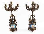 SEVRES - SUNTUOSO PAR DE CANDELABROS  EM PORCELANA E BRONZE ORMOLU. PORCELANA NA TONALIDADE AZUL CELESTE REMATADA EM OURO E DECORADA COM CENAS PINTADAS EM ESMALTE RETRATANDO QUERUBINS. O BRONZE TEM LINDOS QUERUBINS QUE SUSTENTAM O FUSTE FINALIZANDO EM CANDELADROS COM SEIS LUMES. A BASE É DECORADA COM REQUINTADOS LAURÉIS. ESTILO E ÉPOCA NAPOLEÃO III. A BRONZERIA EM ORMOLU É DE EXCEPCIONAL QUALIDADE. FRANÇA, DEC. 1870. 51 CM