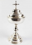 GRANDE AMBULA EM PRATA DE LEI BATIDA. INTERIOR COM EXUBERANTE VERMEIL. FUSTE BALAÚSTRE ROSQUEÁVEL. TAMPA ENCIMADA POR CRUZ LATINA. BRASIL, SEC. XVIII. 28 CM DE ALTURA. 660 G