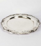 SALVA CIRCULAR EM PRATA DE LEI COM MARCAS PARA PORTUGAL (ÁGUIA) E TEOR 800. BORDA RECORTADA, CINZELADA COM ROCAILLES VEGETALISTAS. PORTUGAL, INICIO DO SEC. XX. 34 CM DE DIAMETRO. 1015 G
