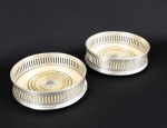 PRATA DE LEI INGLESA - PAR DE BELOS COASTERS (PORTA GARRAFAS) EM PRATA DE LEI COM MARCAS PARA CIDADE DE LONDRES E LETRA DATA PARA O INICIO DO SEC. XX. ELEGANTE CONSTRUÇÃO AO GOSTO EDUARDIANO. BORDA FENESTRADA E FUNDO EM MADEIRA DECORADA COM SULCOS FORMANDO ANÉIS CONCÊNTRICOS E AO CENTRO ARREMATE TAMBÉM EM PRATA DE LEI. INGLATERRA, INICIO DO SEC. XX. 12 CM DE DIAMETRO.