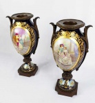 SEVRES  BELO PAR DE ÂNFORAS EM PORCELANA COM GUARNIÇÃO EM BRONZE. FUNDO NA TONALIDE AZUL COBALTO. RICAS RESERVAS COM CENAS GALANTES DE CORTE E PAISAGENS NA FACE OPOSTA. RICOS ARREMATES EM OURO COM BARRADO E GUIRLANDAS VEGETALISTAS. A BASE POSSUI RESERVAS COM SÍMBOLOS LIGADOS AO ROMANCE. FRANÇA, SEC. XIX. 36 CM DE ALTURA