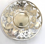 CENTRO DE MESA EM PRATA DE LEI ESTILO E ÉPOCA ART DECO. MARCAS DE CONTRASTE PARA PORTUGAL (ÁGUIA). DECORADA EM FENESTRAS COM FRUTAS DIVERSAS SENDO  PERAS MAÇAS E UVAS. PORTUGAL, SEC. XX. 23 CM DE DIAMETRO. 185 G