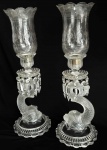 BACCARAT MODELO DOLPHIN  PAR DE CANDELABROS EM CRISTAL MOULE DE BACCARAT ESTILO NAPOLEÃO III. BASE RECORTADA, DECORADA EM GODRONS. FUSTE COM FEITIO DE DOLPHINS FINALIZADOS EM SATINE. DAS BOBECHES PENDEM PRISMAS DE CRISTAL. CÚPULAS LAPIDADAS COM GUIRLANDAS FLORAIS E ENCAIXE NA BASE EM METAL. FRANÇA, INICIO DO SEC. XX. 52 CM DE ALTURA (uma das cúpulas tem imperceptível bicado na borda)