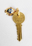 DOM  ANTONIO ALVES DE SIQUEIRA  - CHAVE DO HOSPITAL NOSSA SENHORA DE FATIMA DA BENEFICIÊNCIA PORTUGUESA- OURO 18K E METAL DOURADO. OFERECIDA A DOM ANTONIO ALVES DE SIQUEIRA, ENTÃO BISPO AUXILIAR DE SÃO PAULO, EM 08 DE OUTUBRO DE 1953. A CHAVE É EM METAL DOURADO DE ONDE PENDE ARGOLA EM OURO 18K ATADA A UMA MEDALHA EM OURO 18K COM RESERVA EM PORCELANA.  A ARGOLA TEM A INSCRIÇÃO CHAVE DO HOSPITAL DE NOSSA SENHORA DE FÁTIMA. NA MEDALHA A DATA 8  10  - 1953 , M. REC (MERITO E RECONHECIMENTO) E AS INICIAIS S.P.B (SOCIEDADE PORTUGUESA DE BENEFICIÊNCIA). EM 8 DE OUTUBRO DE 1853  A IMAGEM PEREGRINA DE NOSSA SENHORA DE FÁTIMA FOI CONDUZIDA AO TERRENO QUE ABRIGARIA O HOSPITAL DA SOCIEDADE DE  BENEFICIÊNCIA PORTUGUESA DE NOSSA SENHORA DE FÁTIMA. NESSE ATO DOM ANTÔNIO RECEBEU A CHAVE SIMBÓLICA DO HOSPITAL E ABENÇOOU AS OBRAS DE CONSTRUÇÃO. BRASIL, SEC. 50, 7,5 CM DE COMPRIMENTO.NOTA: Oferecer a chave da cidade a alguém, na época medieval, significava conferir confiança e honra. Esse costume se originou na cidade medieval murada, cujos portões eram guardados durante o dia e trancados à noite. A chave simboliza a liberdade do destinatário de entrar e sair da cidade à vontade, como um amigo de confiança dos residentes da cidade. A verdadeira 'Chave da Cidade' funcionaria para abrir os portões da cidade. Hoje em dia, esse hábito foi estendido para Instituições e uma chave ornamental é apresentada a visitantes estimados, residentes ou outros que a cidade ou instituição deseja homenagear. Este prêmio também é conhecido como Liberdade da Cidade; desta forma, a capacidade de acessar "tudo" é vista como o último ato de estima. É cerimonial, um símbolo de agradecimento pelos serviços prestados ou conquistas significativas (cf um grau honorário). Os destinatários recebem de fato uma chave e às vezes uma chave arcaica. Até os dias de hoje quem recebe as chaves da cidade de Londres na Inglaterra além da chave propriamente tem o direito legal de pastorear ovelhas na Ponte de Londres (London Bridge) uma vez por ano. Claro essa prerrogativa não é invocada há séculos embora seja vigente.