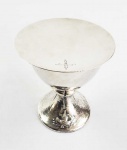 LINDO CÁLICE EM PRATA DE LEI E SUA PATENA FINALIZADO EM MARTELÊ. DE INSPIRAÇÃO GÓTICA. CORPO BOJUDO, INTERIOR COM VERMEIL.MARCAS DE CONTRASTE PARA OS PAISES BAIXOS. BASE POSSUI EM RELEVO A REPRESENTAÇÃO DO MILAGRE DE CRISTO DA MULTIPLICAÇÃO DOS PÃES E DOS PEIXES. A PATENA TEM CINZELADA UMA CRUZ LATINA. SEC. XIX/XX. PAÍSES BAIXOX, 16 X 12 CM. 680 GNOTA: Muitos teólogos da Igreja já fizeram a analogia entre o MILAGRE DA MULTIPLICAÇÃO DOS PEIXES e a EUCARISTIA. Segundo o Padre Raymond Grave, 0 pão é o símbolo do trabalho humano. Ele tem sua importância em todas as culturas; significa a contribuição humana na transformação do trigo que se torna alimento dos humanos. O peixe também tem sua simbologia, pois a cena contada se passa perto do Lago da Galileia, onde os primeiros discípulos eram pescadores. No momento da Eucaristia, o peixe desaparece, mas conserva toda a sua simbologia para designar a Igreja do primeiro século. A palavra grega Ichthys é uma verdadeira profissão de fé cristã no Cristo da Páscoa; cada letra tem seu significado: Isous Christos Theou Yios Str, que significa Jesus Cristo, Filho de Deus, Salvador.  Segundo o evangelho, os Discípulos se dirigiram a Cristo preocupados com a situação dos que estiveram por dias ouvindo seus sermões;() Despede as multidões para que vão aos povoados comprar alimento para si Só temos aqui cinco pães e dois peixes. E segue: Tenho compaixão da multidão, porque já faz três dias que está comigo e não tem o que comer. Não quero despedi-la em jejum, de modo que possa desfalecer pelo caminho. E assim deu-se o milagre. Em suma, a ceia da multiplicação dos pães oferecida pelo Senhor a Seu povo é prenúncio da Ceia Eucarística ou do Banquete Celeste, símbolo da bem-aventurança definitiva.