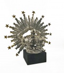suntuoso conjunto de resplendor e coroa em prata de lei pertencente a imagem de nossa senhora da soledade. coroa com hastes construidas em feitio de folhas de acanto, unidas por esfera representando globo terrestre entre pétalas formando desenho de flor. sobre o globo cruz latina. o resplendor é magnifico! possui sete estrelas em sua extremidade representando as sete dores de nossa senhora. grandioso e magnífico. Acompanha expositor em veludo. sec. xix. resplendor 50 cm de altura x 61 cmd e largura. coroa 27 x 26 cmnota: NOTA: Nos primeiros séculos do cristianismo, quando os cristãos saíram das catacumbas e puderam exercer livremente o culto, apareceram os primeiros crucifixos, como símbolos da redenção. Mais tarde, começaram a colocar, junto à cruz, a imagem da Virgem Dolorosa. Ela recebeu então a denominação de Senhora da Soledade, palavra derivada do latim, que significa solidão, tristeza e saudade. A Mãe de Deus era representada levantando os olhos cheios de lágrimas para o céu ou para a cruz. Algumas vezes aparecia, nas suas mãos, o Santo Sudário de Jesus. Na celebração da Via-Sacra, representando as etapas da Caminhada de Cristo carregando a Cruz, num dos Passos há a cena do encontro de Jesus Cristo com sua mãe Maria, chorando com um lencinho na mão. Deste costume se originou a devoção à Nossa Senhora da Soledade, a mãe sofredora. É a mãe que vive e experimenta, na própria carne, a solidão, o abandono de todos, diante da condenação do Filho sendo levado à morte de cruz. Nossa Senhora da Soledade relembra, ainda, a imensa saudade que a Virgem Maria teve do seu Filho, nos três dias que o seu corpo esteve no sepulcro. O culto a Nossa Senhora da Soledade propagou-se durante o século XVII e XVIII, de maneira especial, em toda a Península Ibérica e nas colônias de Portugal. Conta a tradição popular que, na sequência do terremoto de 1755 que arrasou Lisboa e destruiu algumas zonas ribeirinhas da margem sul do Tejo, os sobreviventes em meio ao maremoto que se seguiu ao terremoto os sobreviventes acorreram as ruínas da igreja de Nossa Senhora da Soledade e a recolheram, levando-a a margem do rio. Levando-a até à margem do Rio onde ocorreu prodigioso milagre, a Santa desceu as mãos que estavam cruzadas no peito, e a água começou a abaixar lentamente.