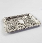 PRATA DE LEI INGLESA - WALKER & HALL  ELEGANTE PORTA CORRESPONDÊNCIAS EM PRATA DE LEI COM MARCAS PARA CIDADE DE SHEFFIELD. ESTILO VITORIANO É DECORADA COM LINDAS ROCAILLES COM FLORES E RAMAGENS RELEVADAS. AO CENTRO ESCUDELA.. INGLATERRA, 1902. 25,3 X 20 CM
