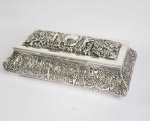 PRATA DE LEI VITORIANA - GRANDE CAIXA EM PRATA DE LEI COM INTERIOR REMATADO EM VERMEIL. MARCAS PARA CIDADE DE LONDRES E LETRA DATA PARA 1896. COM ELEGANTE FEITIO È DECORADA EM RELEVO COM LINDAS FIGURAS DE CUPIDO CAÇANDO COM SEU ARCO E FLEXA PATOS EM VOO ACOMPANHADO POR  CÃES DE CAÇA. INGLATERRA, SEC. XIX. 28 CM DE COMPRIMENTO. 780 G (PESO TOTAL)