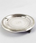 BELA SALVA BILHETEIRA EM PRATA DE LEI ESTILO DONA MARIA I. DECORADA COM PROFUSOS E BELOS GUILLOCHES. RESERVA TEM ELEGANTE MONOGRAMA COM AS LETRAS JMSM. MARCAS DO PRATERIO NO PLANO. ASSENTE SOBRE TRÊS BELOS PÉS EM GARRA, BRASIL, PRIMEIRA METADE DO SEC. XIX. 17,5 CM DE DIAMETRO.