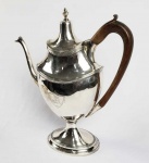 FORMIDÁVEL CAFETEIRA DE COLEÇÃO EM PRATA DE LEI ESTILO E ÉPOCA DONA MARIA I. MARCAS DE CONTRASTE PARA A CIDADE DO PORTO (P COROADO) E PRATEIRO IDENTIFICADO POR MOITINHO COMO CONTRASTE P52 (PAG 236) ATIVO EM 1810. ALÇA EM MADEIRA DECORADA COM CARAPETA. NO CENTRO CAPRICHADO CINZELADO COM ESCUDELA REMATADA POR LAURÉL. PEÇA DIGNA DE MUSEU! PORTUGAL, INICIO DO SEC. XIX. 32,5 CM DE ALTURA. 1115 G