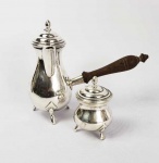 CAFETEIRA E AÇUCAREIRO EM PRATA DE LEI. CAFETEIRA TEM PEGA LATERAL COM CABO EM MADEIRA. ELEVADAS SOBRE TRÊS PÉS. MARCAS DE CONTRASTE 833 E PRATEIRO ALVES PINTO. 18 CM DE ALTURA (CAFETEIRA). PEQUENAS MOSSAS NO BULE. 455 G