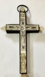 CRUZ RELICÁRIO DA TERRA SANTA  BELO RELICÁRIO COM ESTRUTURA EM MADEIRA PROVAVELMENTE OLIVEIRA, REVESTIDA DE PLACAS E INCRUSTAÇÕES EM MADREPÉROLA, ORNADA DE ELEMENTOS ICONOGRÁFICOS CRISTOLÓGICOS SENDO CRISTO CRUCIFICADO E A VIRGEM DOLOROSA AOS SEUS PÉS.  MARIANOS E VEGETALISTAS, RELEVADOS E INCISOS. REPRESENTA CRISTO CRUCIFICADO AO CENTRO, AOS SEUS PÉS FIGURA DE SÃO JOÃO EVANGELISTA, NA BASE BELA REPRESENTAÇÃO DE SANTA CATARINA DE ALEXANDRIA. NAS HASTES DA CRUZ TEMOS DO LADO DIREITO NOSSA SENHORA DAS DORES E DO ESQUERDO SANTA MARIA MADALENA. A EXECUÇÃO, DE CERTA MANEIRA PRIMITIVA, SUPERA-SE NA RIQUEZA DA ICONOGRÁFICA DE GRANDE CONTEÚDO SIMBÓLICO, ONDE SE CONJUGAM ELEMENTOS NO CARÁTER ORNAMENTAL CONFERIDO PELO DINÂMICO RECORTE DA ESTRUTURA E PELA APLICAÇÃO DE PLACAS OU INCRUSTAÇÕES DE MADREPÉROLA, ONDE SE GRAVARAM OS ELEMENTOS ICONOGRÁFICOS TEMÁTICOS, ESTRATEGICAMENTE COLOCADOS DE ACORDO COM A HIERARQUIA DA IGREJA. NA PARTE POSTERIOR RELÍQUIAS DAS ESTAÇÕES DA VIA CRUCIS IDENTIFICADAS DE ACORDO COM A ESTAÇÃO. A CRUZ DE TIPOLOGIA LATINA, SECÇÃO RETANGULAR, HASTES TRILOBADAS É UM BELO EXEMPLAR DE RELÍQUIA DA TERRA SANTA! SEC. XVIII, 23 CM DE ALTURANOTA: A ação dos cruzados, o combate à propagação das heresias, os movimentos evangelizadores, sobretudo no novo mundo, ou os confrontos decorrentes do movimento reformista do séc. XVI, foram terreno fértil, viveiros de mártires e por isso propiciadores do mercado de relíquias e a expansão e incremento do culto das mesmas. Bispos e abades procuraram dotar as suas catedrais ou abadias destas insignes relíquias que atraíssem a piedade dos fiéis. Muitas vezes se recorria à sua circulação tournées de reliques, a fim de financiar ou concluir a sua construção. Para dar notoriedade e autenticidade aos milagres escreviam-se os Libelli e liam-se ao povo muitas vezes perante aqueles sobre quem tinha recaído o milagre. Guardadas em criptas ou capelas radiantes, expostas em tabernáculos nas sacristias ou nas naves das igrejas, nos coros conventuais, ou em capelas relicário. Foram também objeto de culto em espaço privado, de doação e oferta entre os reinos e os senhores, laicos e religiosos, particular expressão da devoção feminina, que no seu espaço íntimo possuía as suas capelas com os seus oratórios e os seus relicários com as mais poderosas e inesperadasrelíquias. Simultaneamente assiste-se ao incremento das falsificações e do seu comércio ilícito. Já em 386 o Imperador Teodósio (347-395) chamava à atenção para as prescrições em vigor relativas ao desmembramento dos corpos, cujo comércio se tinha tornado muito lucrativo. No século IX, constitui-se em Roma uma associação consagrada à venda de relíquias. No Concilio de Latrão (1215) proíbe-se a veneração de objetos sem autorização. Os Padres da Igreja convictos da importância e capacidade mobilizadora deste culto, esforçam-se por esclarecer o seu duplo caráter. A veneração destina-se à pessoa não ao objeto ou fragmento, e só tem lugar, na sua relação com Cristo. Na XXV sessão do Concílio de Trento, de 3 Dezembro de 1556, afirma-se a importância das relíquias, postulando a legitimidade da sua veneração, ao mesmo tempo, que se exigia a sua avaliação e creditação. Concílios, Constituições Sinodais e Livros de Visitas testemunham essa preocupação de fundamentar e estimular o culto, mas também de efetiva fiscalização do cumprimento das normativas estipuladas que asseguravam a sua autenticidade e boas práticas (manuseio, transladação, recetáculos e locais de guarda e exposição) e o legitimam.