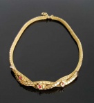 BELO COLAR EM OURO 18K  CONSTRUÍDO EM MALHA DO TIPO COTA REMATADA POR PASTILHAS JUSTAPOSTAS COM FEITIO DE CIRCULOS. POSSUI TAMBÉM NA PARTE CENTRAL UM ENTRELAÇAMENTO DECORADO COM FLORES COM MIOLOS EM PEDRA NA TONALIDADE VERMELHA. EUROPA, SEC. XX. 42 CM DE COMPRIMENTO. 45,8 G