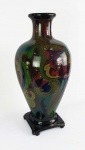 GOUDA  MONUMENTAL E BELO VASO EM CERÂMICA MULTICOLORIDA COM ESMALTES ESTILO E ÉPOCA ART DECO. ASSENTE SOBRE BASE EM MADEIRA. HOLANDA, INICIO DO SEC. XX.  59 CM DE ALTURA. NOTA: É difícil resistir ao encantamento que a alegre mas harmoniosa decoração das peças Gouda causam ao admirador. Gouda é um estilo de cerâmica holandesa com o nome da cidade de Gouda, onde foi fabricado historicamente. A cerâmica Gouda ganhou proeminência mundial no início do século 20 e continua sendo altamente desejável para os colecionadores de hoje. A cerâmica de Gouda é diversa e visualmente distintiva na aparência, tipicamente ilustrada com desenhos coloridos e altamente decorativos no estilo Art Nouveau ou Art Deco.