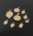 LOTE COM NOVE MEDALHAS SACRAS DIVERSAS EM  OURO 18K., SENDO: GRANDE MEDALHA DE NOSSA SENHORA APARECIDA, (4,5 CM), MEDALHA DE NOSSA SENHORA DO CARMO (2,5 CM DE DIAMETRO), SANTA TEREZINHA DE JESUS (2,3 CM DE DIAMETRO), SANTO ANTONIO COM FEITIO DE CORAÇÃO, NOSSA SENHORA APARECIDA RETANGULAR, SANTA TERESINHA, SÃO JOSÉ, NOSSA SENHORA DE FÁTIMA E AGNOS DEI. 14,6 G