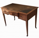 BELO BUREAU EM MADEIRA DOTADO DE TRÊS GAVETAS .  ASSENTE SOBRE RODÍZIOS. INGLATERRA, INICIO DO SEC. XX. 74 X 106 X 62 CM  (desgaste no verniz e falta um puxador)