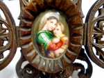 Mini oratório de madeira ricamente entalhado, para viagem e/ou mesa . Imagem de Nossa Senhora e Menino. Provável pintura esmaltada . Medidas : 15 x 10 aberto e 13 x 7,5 fechado.