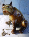 Escultura em porcelana representando " Cachorro BULDOGUE ". O cachorro está sentado e apresenta coloração própria da raça. Peça numerada . Altura 13 x 12 cm.
