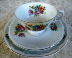 Trio de Xícara de chá com pires e prato para bolo em porcelana esmaltada branca e vitrificada com ramos  alegres de  buques de  flores Peças  com chanfrados em alto relevo e frisos em ouro. 18 /15 / 8 de altura , porcelana de STA CATARINA Schmidt