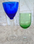 Duas taças altas coloridas , sendo uma azul em cristal com 22 cm de altura  com hastes facetadas  e uma verde de 16 cm com linda lapidação.