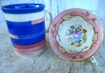 Duas peças inglesas : uma Caneca esmaltada e vitrificada no tom azul e branca medindo 10 cm /8 cm e xícara em porcelana TUSCAN com ornamentação de faixa rosa e flores ( sem pires )