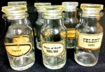 Conjunto de seis vidros de farmácia em vidro translucido com diferentes identificações de conteudo. Altura 10 cm.