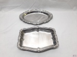 Lote de 2 travessas em aço inox, sendo uma retangular e uma oval. Medindo a retangular 25cm x 18cm x 3,5cm de altura.