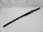 Katana decorativa com lâmina em aço sem fio, punho revestido com tecido e acabamento em metal e bainha em resina. Medindo 89cm de comprimento sem bainha e 98cm de comprimento com bainha.