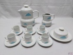 Jogo de servir café com 9 peças em porcelana Schmidt nuvem azul. Sendo 6 xícaras com pires, bule, leiteira com leve bicado na parte interna e manteigueira.