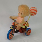 Brinquedo antigo - Graciosa criança sentada na bicicleta de lata. Funcionando (Veja o Vídeo). Fabricada em Hong Kong. Mede 12,5cm de altura x 12cm de comprimento